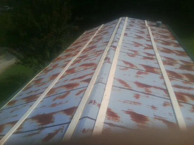 Rusted metal roof panels with new wood purlins before replacement — Storm Damage Roof Repair in Ashton by Roofing Brothers